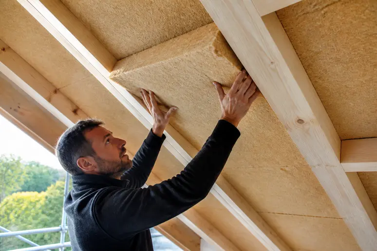 Pose de panneaux de laine de bois sous la charpente pour l'isolation naturelle des combles