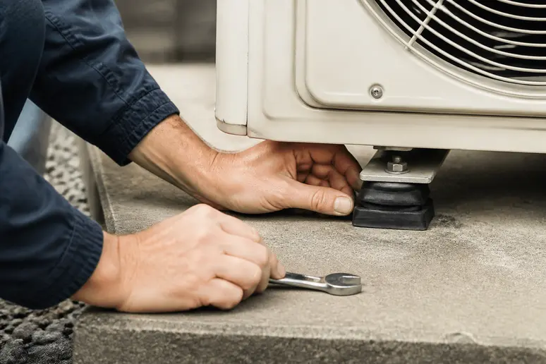 Installation de plots antivibratoires sous les pieds d'une pompe à chaleur pour réduire les transmissions sonores.