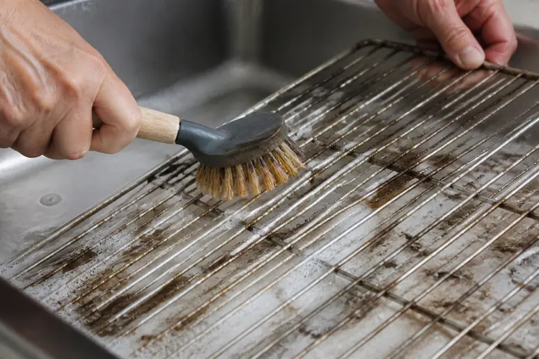 Application d'une solution sur grille de four pour nettoyer sans pyrolyse.