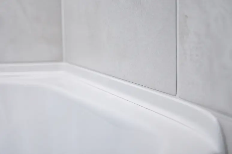 Gros plan sur un joint en silicone blanc propre autour d'une baignoire