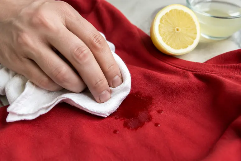 Application délicate de jus de citron sur un textile coloré pour effacer la trace de fruit