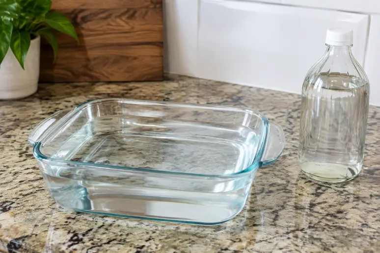 Récipient résistant à la chaleur rempli d'un mélange d'eau et de vinaigre blanc pour l'entretien du four