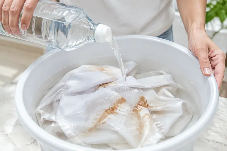 Trempage d'un vêtement taché dans de l'eau tiède et du vinaigre blanc dilué.