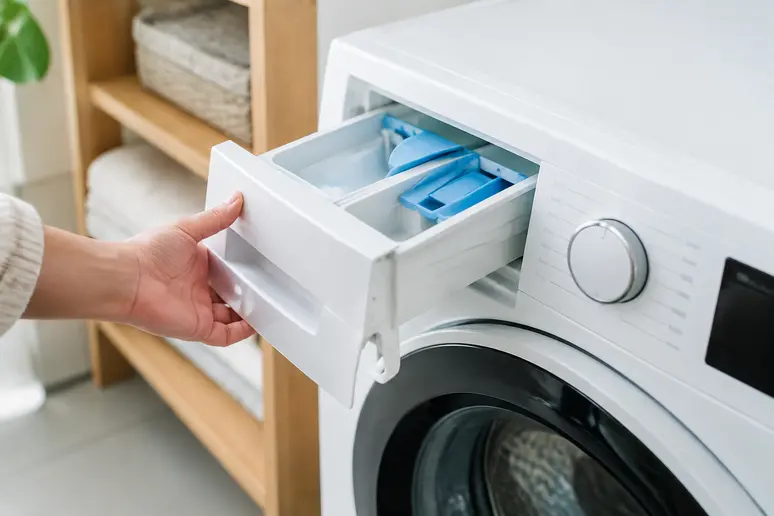 Ouverture du bac à produits d'un lave-linge pour observer l'état de propreté des compartiments