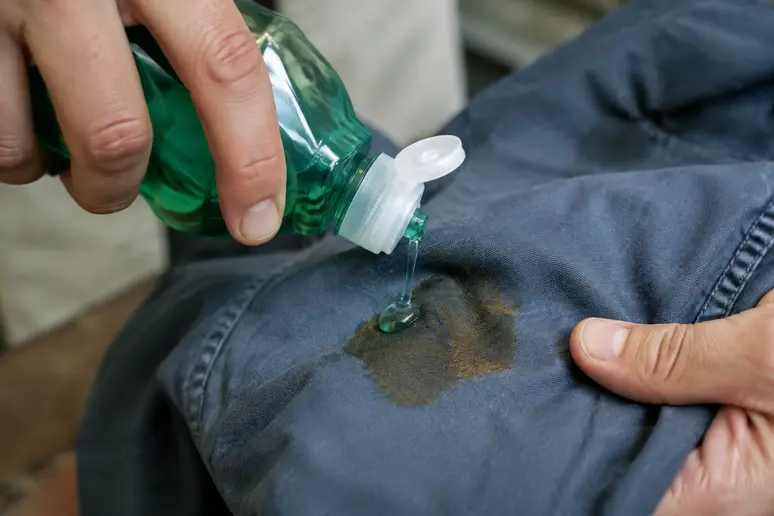 Application de liquide vaisselle sur une tache de cire à épiler sur vêtement