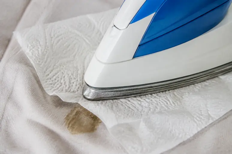 Repassage avec papier absorbant pour enlever la cire sur un vêtement