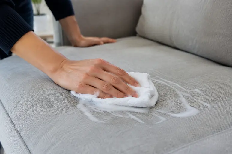Appliquer délicatement la mousse nettoyante sur le canapé en tissu avec un mouvement régulier.